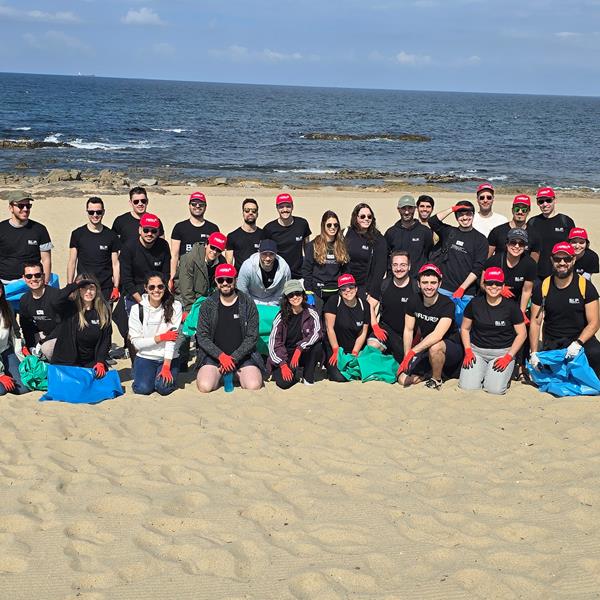 Grupo De Voluntários A Recolher Lixo Durante Uma Limpeza De Praia